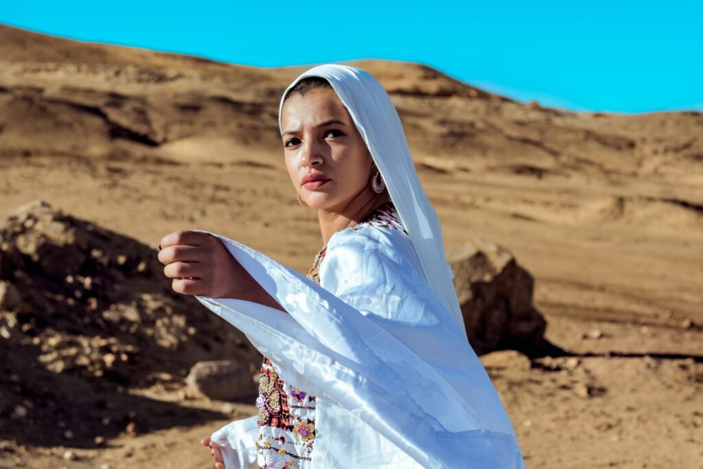 A woman elegantly poses in traditional attire at Siwa Oasis, Egypt.